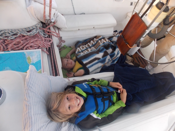 Crew waking up in the morning.  They opt to sleep in the cockpit where seasickness is not so apt to get you.  Logan woke up several times throughout the night to help out with the passage.  Cole has liked sleeping on the floor of the salon or the cockpit since he was a baby.  We are just careful not to step on him!